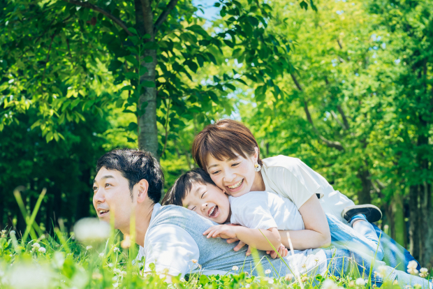 芝生で家族で遊んでいる写真
